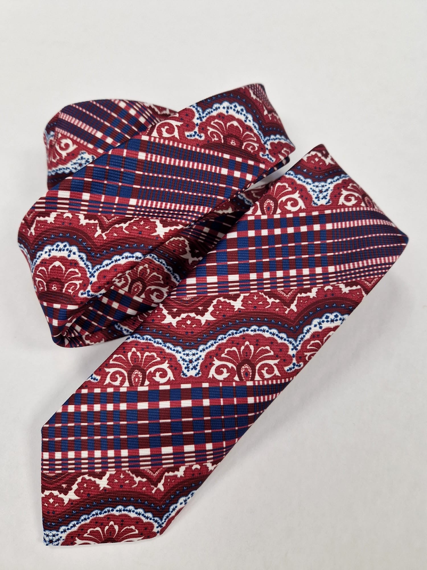 Red and navy paisley plaid silk tie, loosely folded.