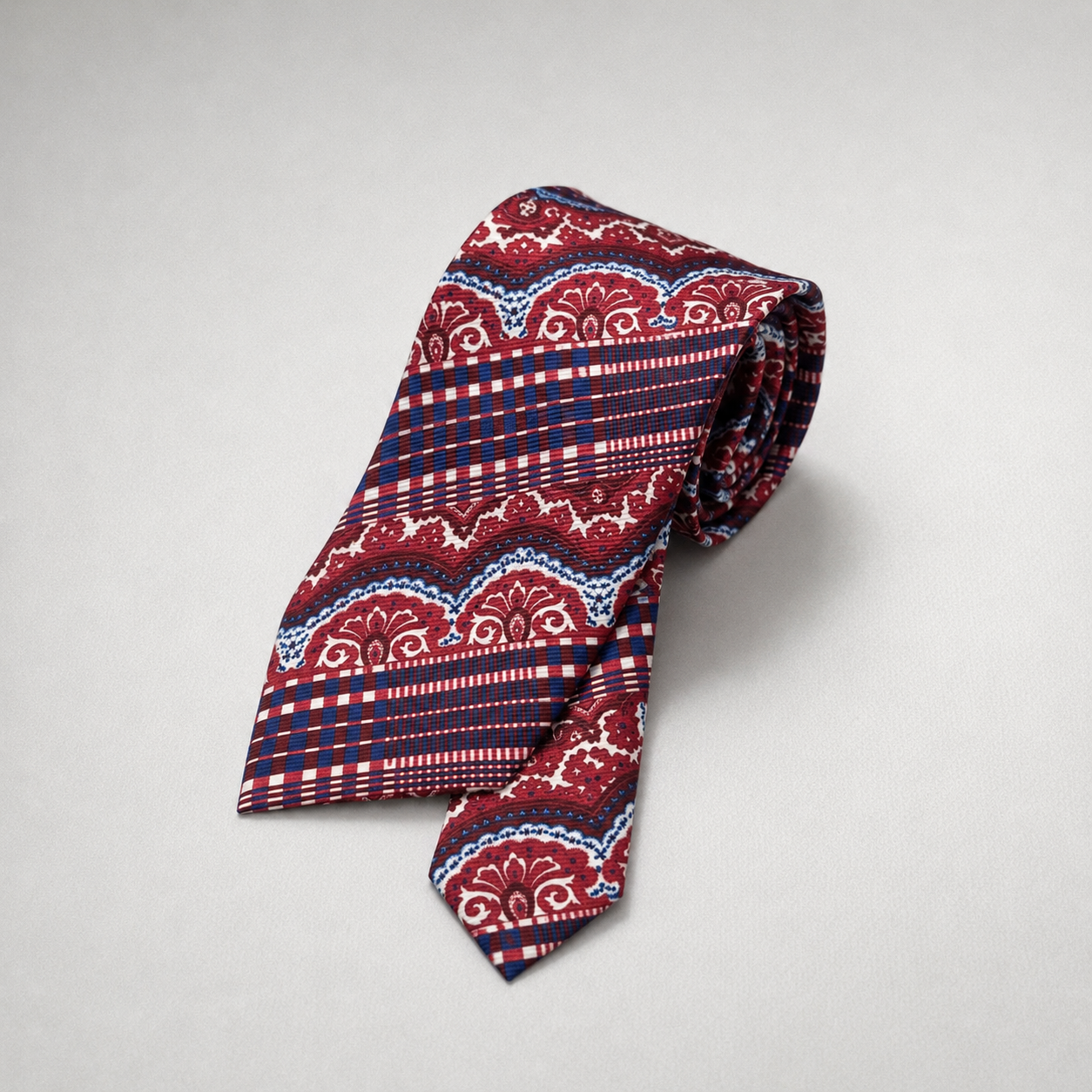 Red and navy silk necktie with paisley and striped patterns.