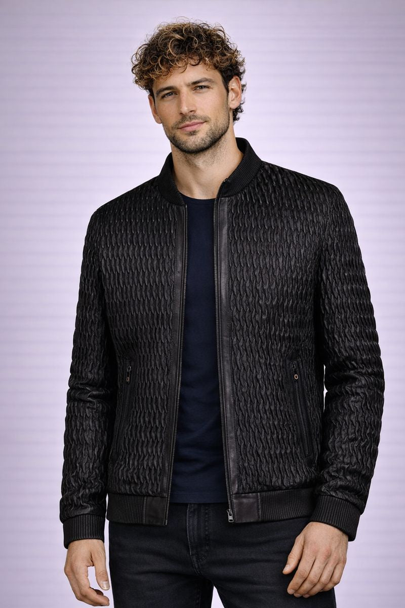 Man wearing a textured black jacket against a light purple background