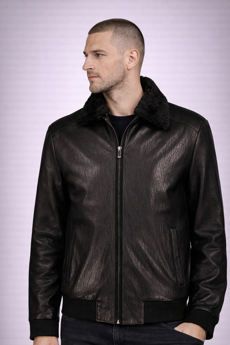 Man wearing a black leather jacket with fur collar on a light purple background