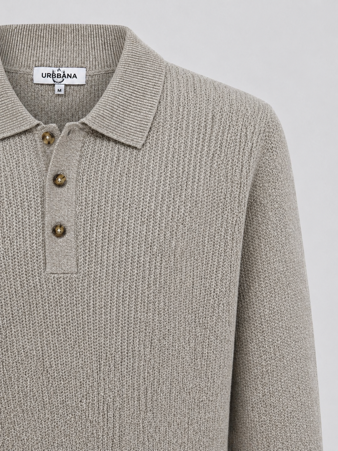 Close-up of a beige long-sleeve knitted polo shirt with brown buttons.