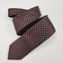 Como silk tie in burgundy with a light blue geometric pattern, loosely folded.