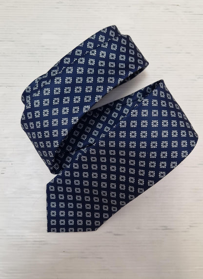 Navy silk tie with a light blue diamond pattern, loosely folded.