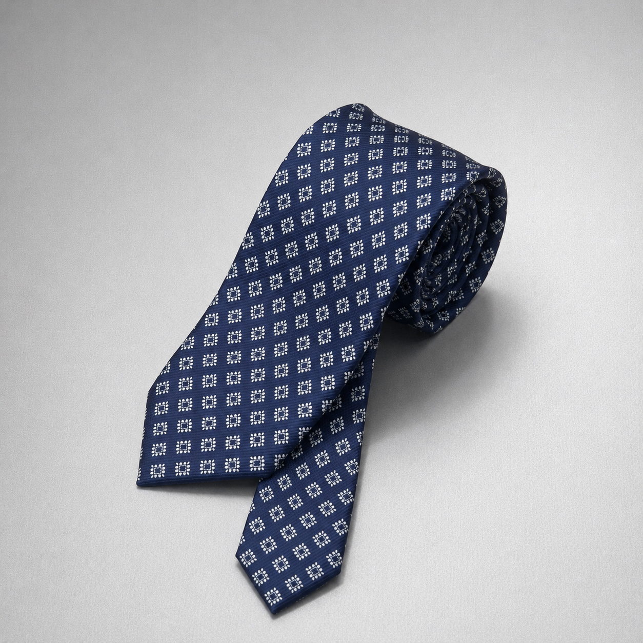 Navy silk necktie with a small light blue diamond pattern.