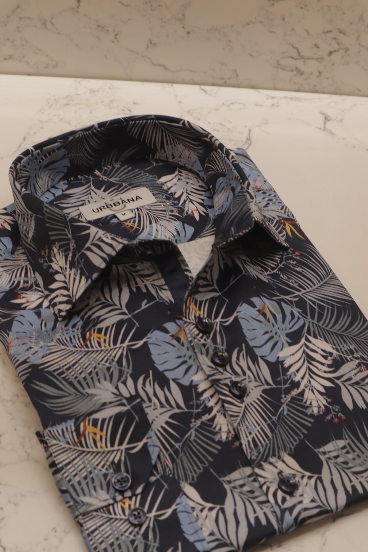 URBBANA navy shirt with palm fronds and yellow flowers.