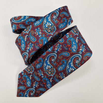 Red, navy and cream ornate paisley silk tie, loosely folded.
