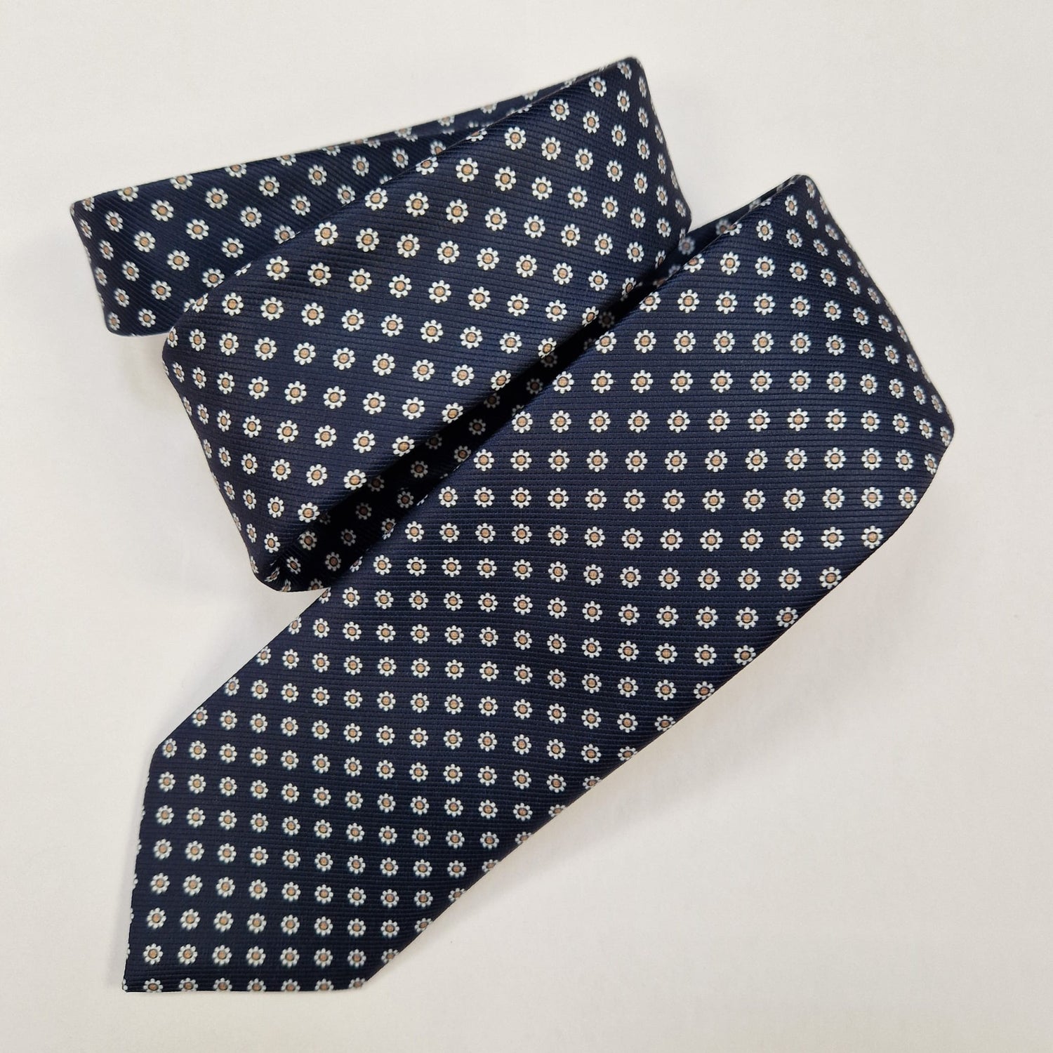 Turquoise and burgundy paisley silk tie, loosely folded.